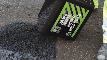 A pothole in the ground is being fixed immediately by using a Instant Pothole Repair ready mixed formula.