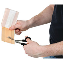 A man using medical shears to cut a plaster